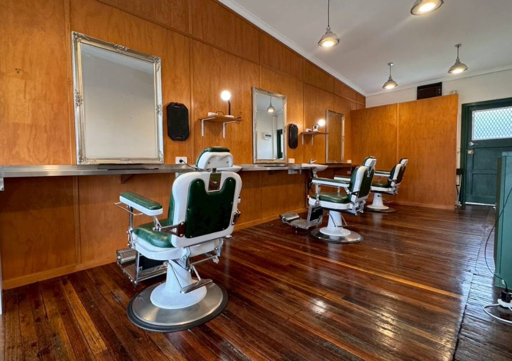 Inside Tokoya: honey timber walls, green leather barber chairs and polished hardwood floors.