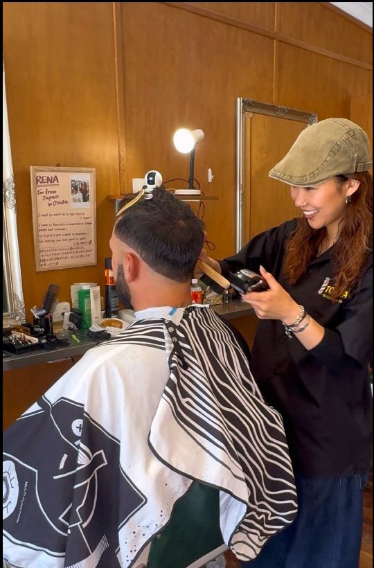 Rena, a Tokoya barber, finishing a fade on a bearded customer.